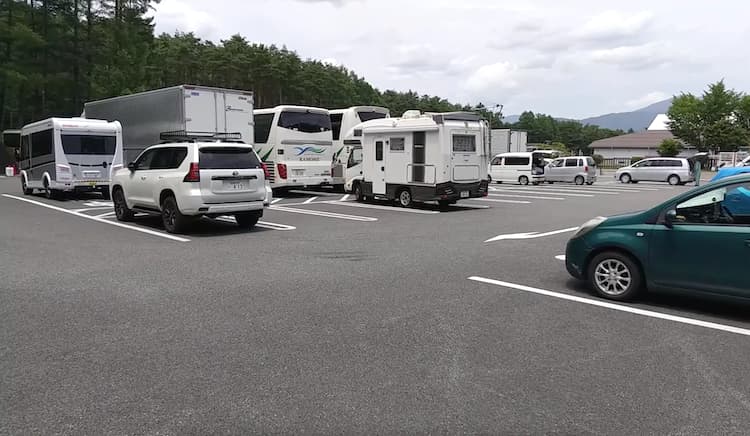 道の駅 富士吉田の富士山レーダードーム公園前駐車場に駐車中のキャンピングカーと乗用車